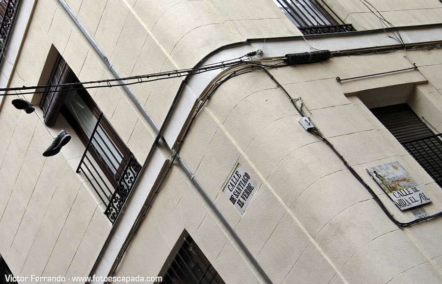 Shoefitiarte urbano en forma de zapatillas colgadas de un cable en Madrid