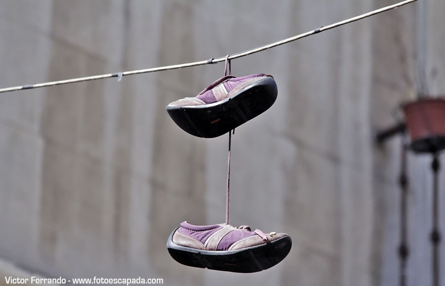 Shoefitiarte urbano en forma de zapatillas colgadas de un cable en Madrid